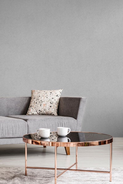 Graue Vliestapete im Wohnzimmer mit Couch und Tisch