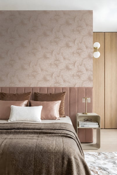 Modernes Schlafzimmer mit gemusterter Tapete mit Fächermotiv, gepolstertem Kopfteil, Nachttisch und Wandleuchte in wohnlichem Design.
