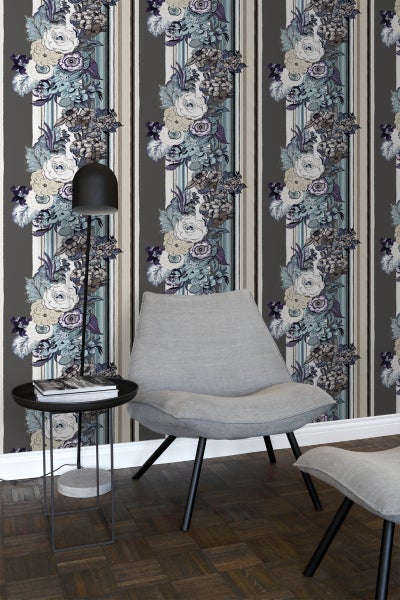 Raumansicht mit gestreifter Blumentapete, Lampe, Tisch und Stuhl