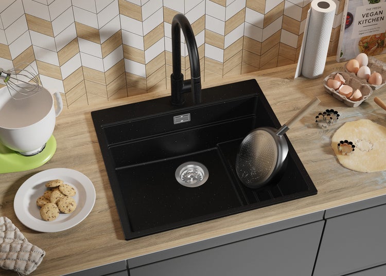 Schwarzes Spülbecken mit Armatur in einer Küche mit Backzutaten