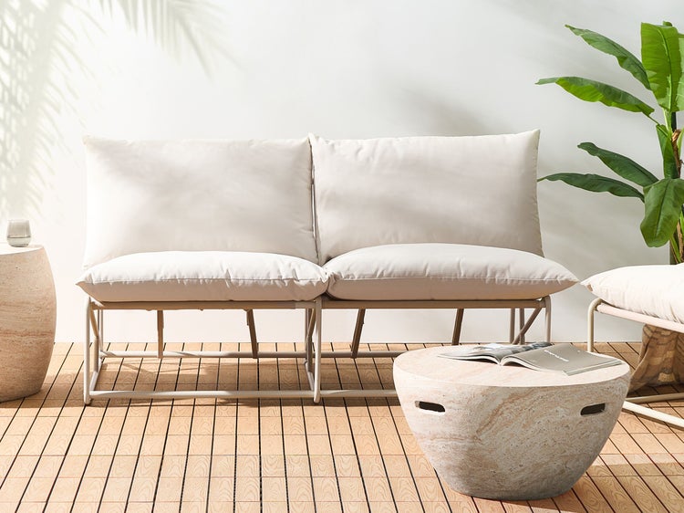 Szene mit Outdoor-Lounge-Möbeln und Beistelltisch auf einer Terrasse.