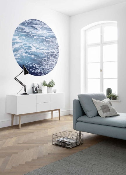 Heller Wohnraum mit Kommode, Sofa und Wandbild