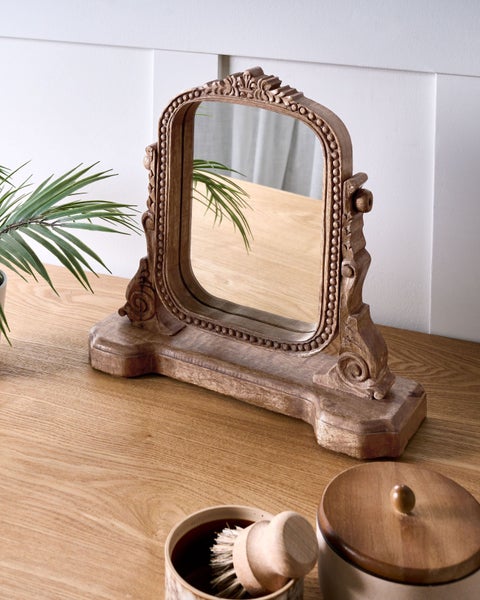 Ovaler Standspiegel mit Holzrahmen und Ornamenten auf einem Tisch