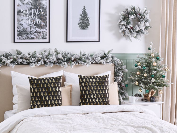 Festlich geschmücktes Schlafzimmer mit Weihnachtskranz, Girlande und kleinem Tannenbaum