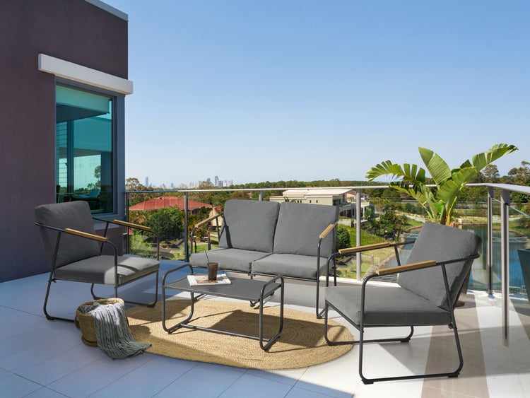 Balkonmöbelset mit Sofa, Sesseln und Tisch auf einem sonnigen Balkon