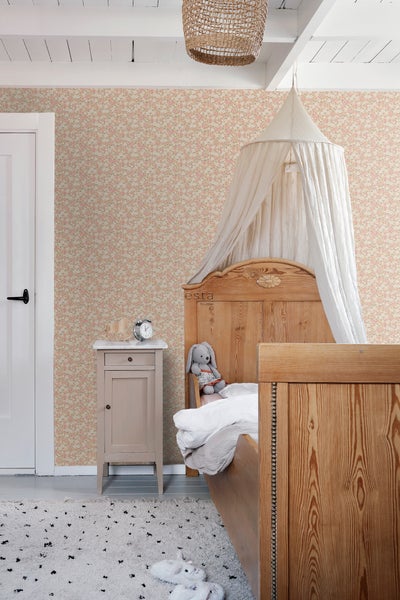 Helles Kinderzimmer mit Bett, Nachttisch, Teppich und geblümter Tapete