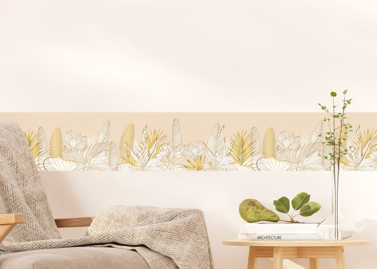 Tapetenbordüre mit botanischen Motiven wie Blättern und Blüten an einer Wand über einem Sessel und einem Beistelltisch.