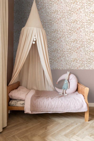 Kinderzimmer mit Himmelbett, floraler Tapete und Holzfußboden