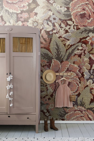Szene mit floral gemusterter Tapete, Kleiderschrank, Hut, Kleid und Stiefeln