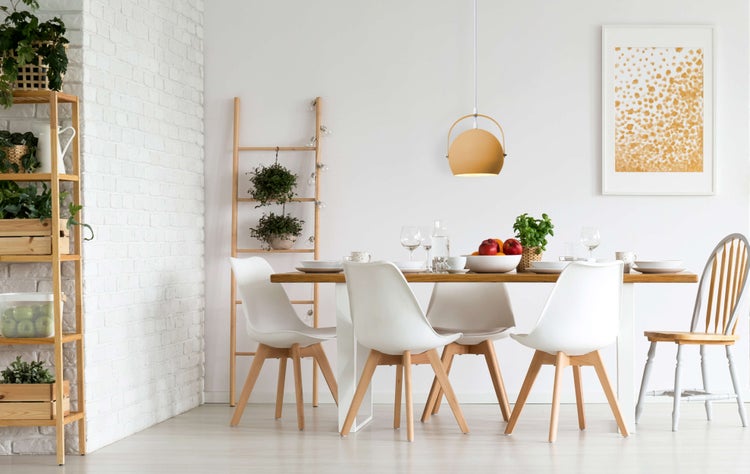 Heller Essbereich mit Holztisch, weißen Stühlen und dekorativen Elementen