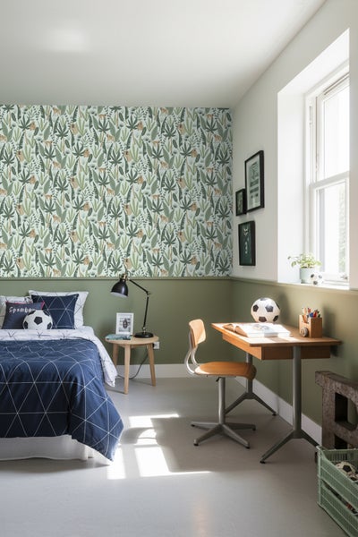 Dekoriertes Jugendzimmer mit Bett, Schreibtisch und Dschungeltapete