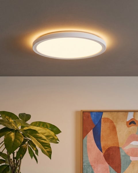 Runde LED Deckenleuchte mit indirekter Beleuchtung in einem modern eingerichteten Wohnraum