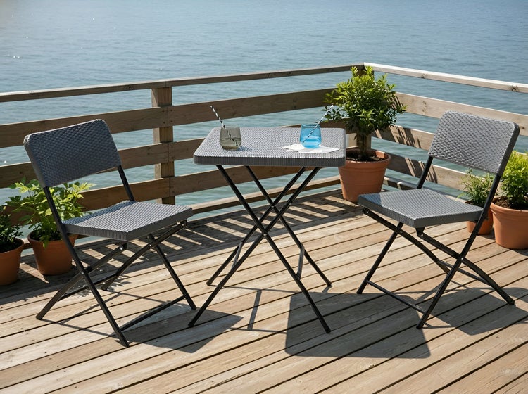 Gartenset mit Klapptisch und zwei Klappstühlen auf einer Holzterrasse