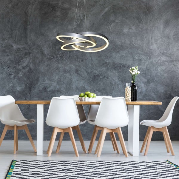 Esszimmer mit Holztisch, weißen Stühlen und moderner Ring-Deckenleuchte.