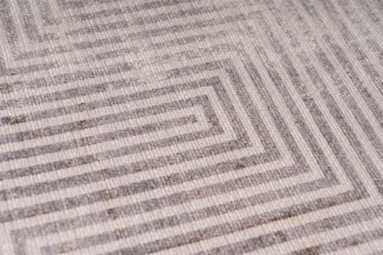 Nahaufnahme eines gewebten Teppichs mit einem geometrischen Muster aus konzentrischen Linien.