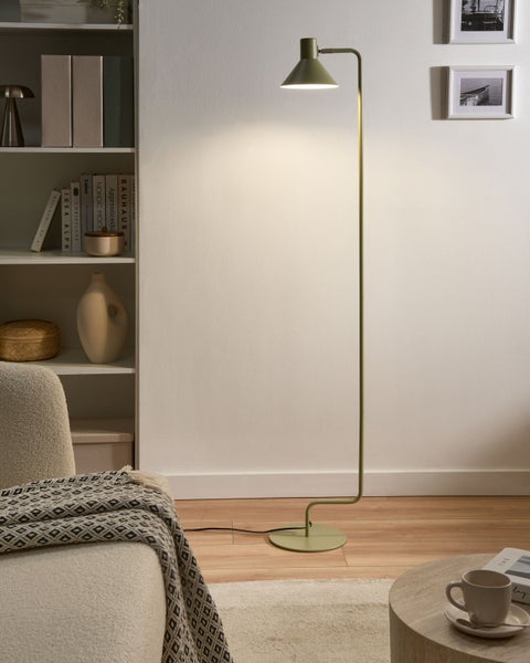 Moderne Stehleuchte mit konischem Schirm in einem hellen Wohnzimmer mit Regal, Sessel und Holzfußboden.