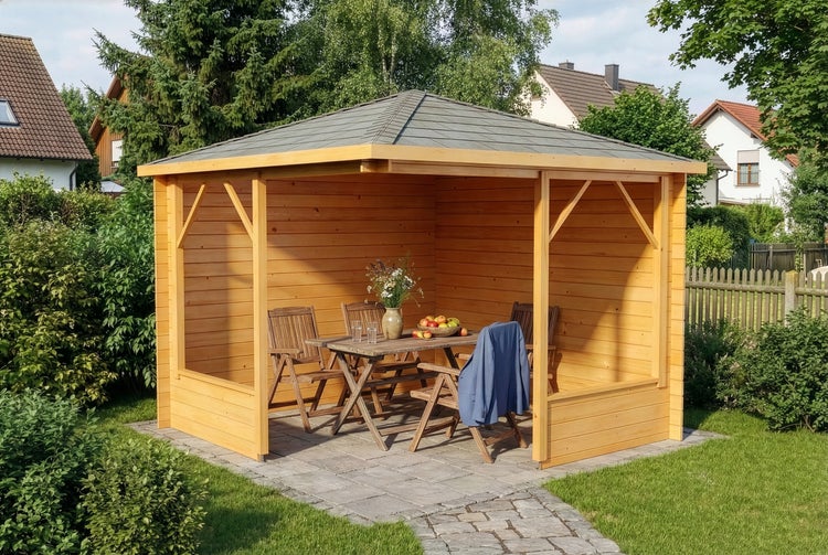 Moderner Holz-Gartenpavillon mit grauem Schindeldach, Ecklounge-Sofa mit hellen Polstern und Holztisch auf einer gepflasterten Terrasse im Garten.