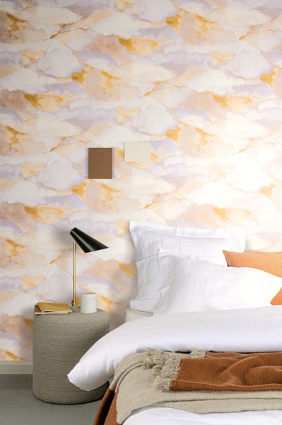 Paar sitzt auf Gartenbank mit Kissen und Polsterauflagen auf Terrasse