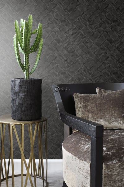 Dekoratives Interieur mit Kaktus, Beistelltisch, Sessel und gemusterter Tapete für ein gemütliches Ambiente.