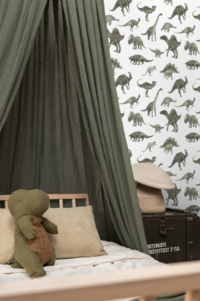Zimmer mit Dinosaurier-Tapete und spielendem Kind mit Holzeisenbahn