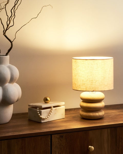 Dekorative Szene mit Tischleuchte, Vase und Schmuckschatulle auf einem Holzschrank.