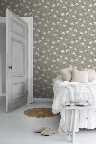 Wohnraum mit beiger Blumentapete, Sofa und Dekorationen für ein gemütliches Ambiente.