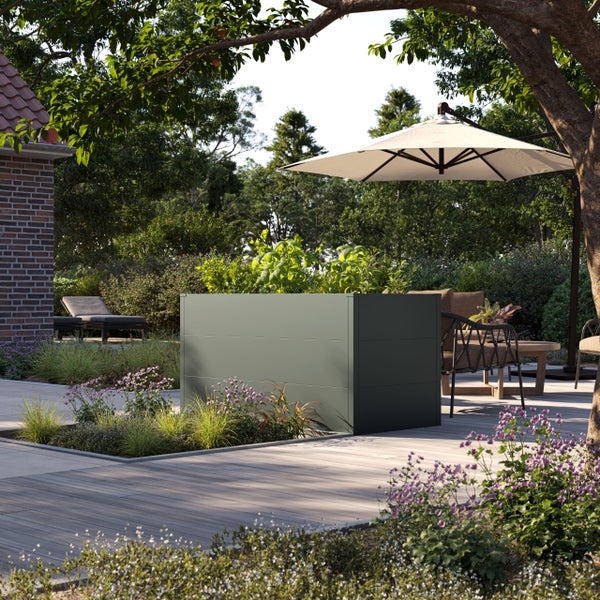 Modernes Hochbeet aus Metall in einem hellen Garten auf einer Holzterrasse mit Sonnenschirm und Gartenmöbeln.