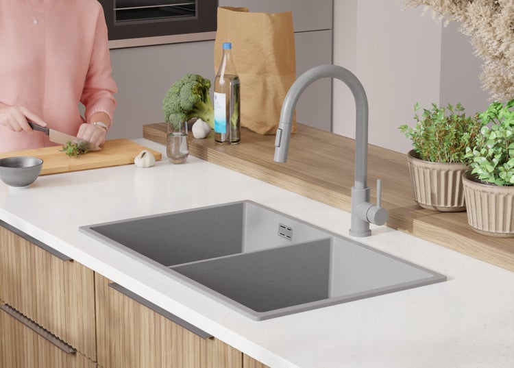 Küchenszene mit Spüle, Armatur und Person beim Kochen