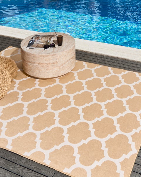 Rechteckiger Teppich mit weißem geometrischem Gittermuster auf pfirsichfarbenem Grund.