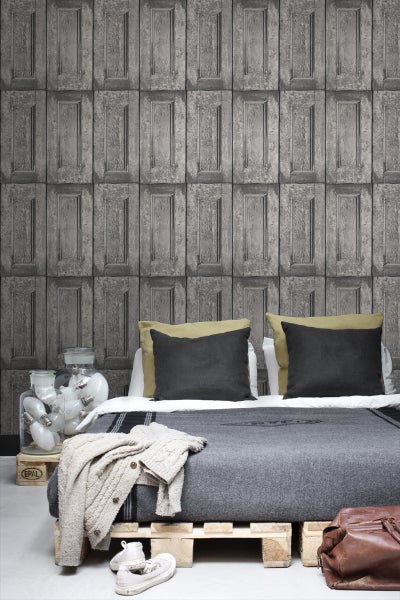 Schlafzimmer mit Bett vor einer Wand mit Paneel Tapete