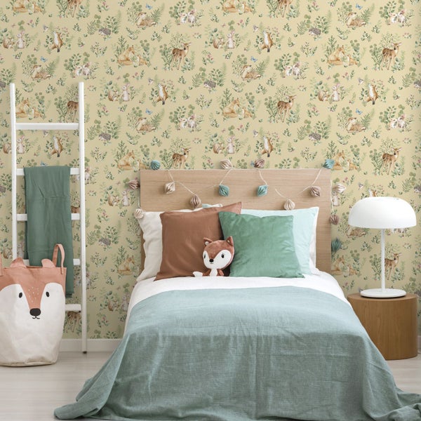 Kinderzimmer mit Vliestapete mit Waldtiermotiv, Holzbetthaupt, weißer Tischleuchte und Aufbewahrungskorb im Fuchsdesign.