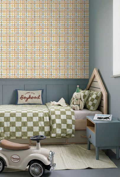 Modernes Kinderzimmer mit karierter Tapete, blauer Wandtäfelung, Hausbett aus Holz, grün-karierter Bettwäsche und einem blauen Nachttisch.