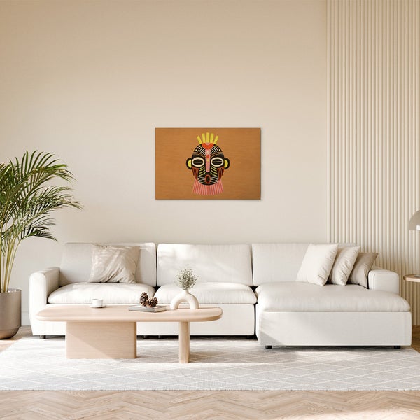 Gemütliches Wohnzimmer mit einem Sofa und einem Wandbild mit afrikanischem Maskenmuster