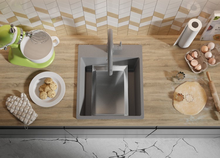 Küchenszene mit Spüle, Rührgerät, Teig und Backutensilien auf einer Arbeitsplatte.