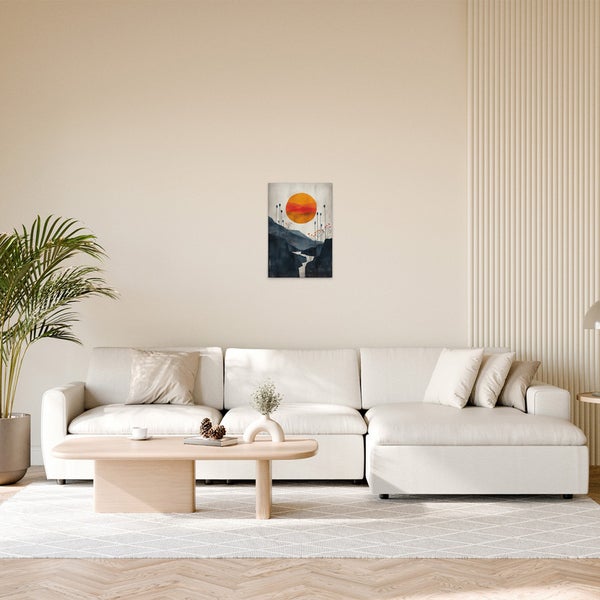 Wohnzimmer mit Sofa und einem Wandbild mit Bergmotiv und Sonne