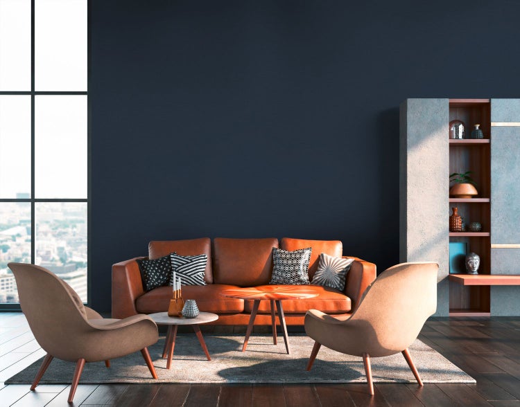 Wohnzimmer mit Rattanmöbeln und Dekoration vor einer dunklen Wand