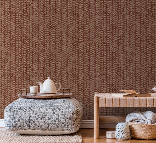 Schlafzimmer mit gemusterter Tapete, Rattanbett und Nachttisch mit Zimmerpflanzen