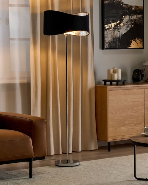 Stehleuchte im Wohnzimmer mit braunem Sessel und Holzkommode