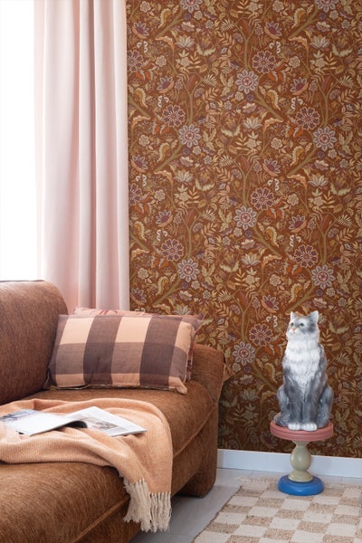 Wohnzimmer mit Couch, Kissen, Tisch und gemusterter Tapete