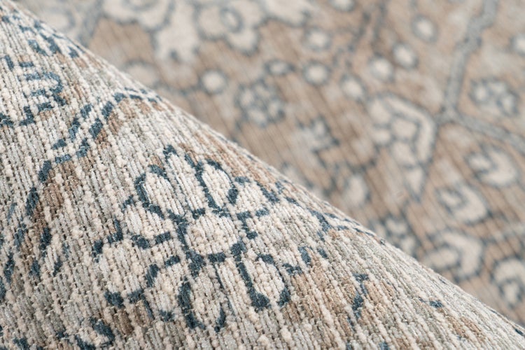 Detailansicht eines gewebten Teppichs mit floralem Ornamentmuster und weichem Flor.