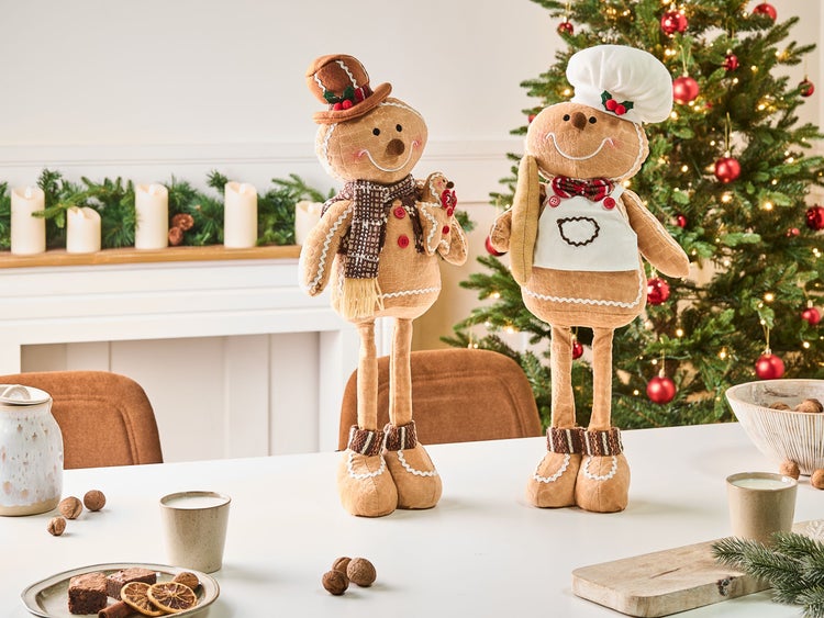 Dekorative Lebkuchenmann Figuren auf einem Tisch vor einem Weihnachtsbaum