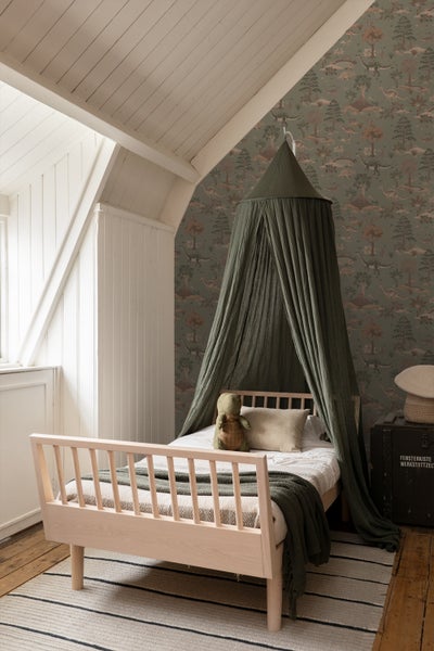 Kinderzimmer mit Holzbett, Baldachin und Dinosaurier-Tapete