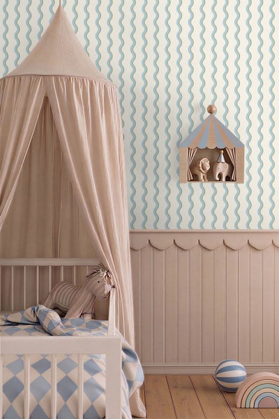 Kinderzimmer mit weißem Gitterbett, rosa Stoffhimmel, Wellenmuster Tapete und hölzerner Wandvertäfelung. Mit Zirkuszelt-Regal und Stofftier.