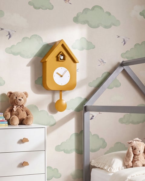 Wandkuckucksuhr in Hausform mit Pendel in einem Kinderzimmer mit Wolkentapete.