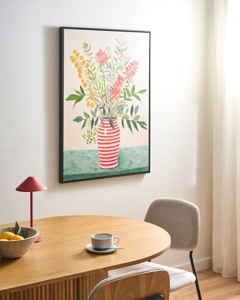 Modernes Wandbild auf Leinwand mit Blumenstrauß in rot-weiß gestreifter Vase über Holztisch in hellem Esszimmer mit Lampe und gepolstertem Stuhl.