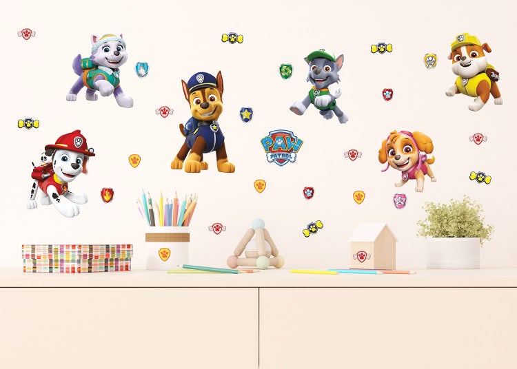 Wandtattoos mit Paw Patrol Charakteren Marshall, Chase, Skye, Rubble, Rocky und Everest sowie Logo auf einer hellen Wand über einem Sideboard.