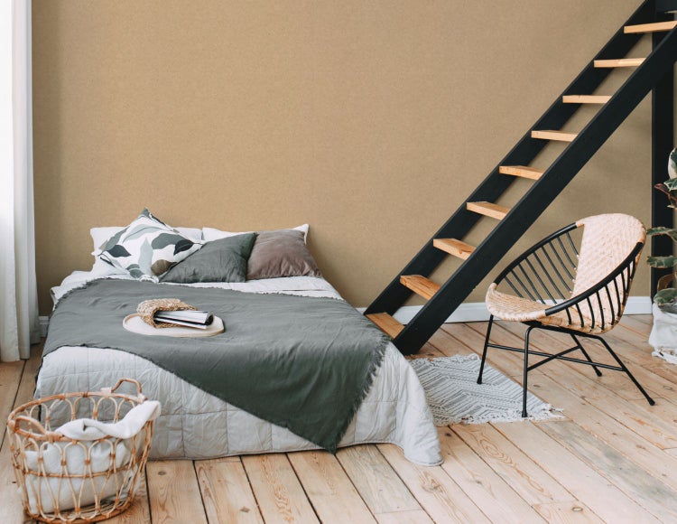 Schlafzimmer mit Bett, Leiter und Korbsessel