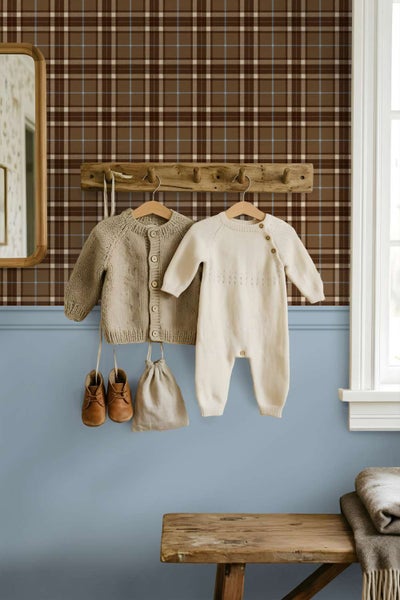 Wandgestaltung mit karierter Tapete und halbhohem Anstrich, dazu eine Holzhakenleiste mit Babykleidung in einem hellen, wohnlichen Raum.