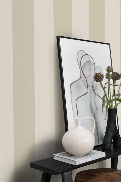 Nahaufnahme von gestreifter Tapete, Dekorationen und einem gerahmten Bild auf einem Tisch