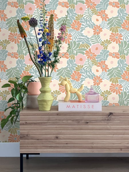 Szene mit floraler Tapete, Kommode und Dekoration